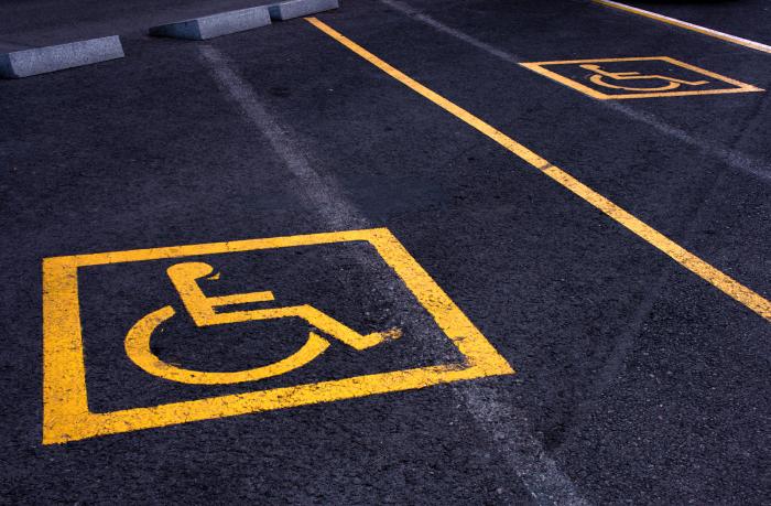 Yellow signs of parking areas reserved for disabled people.